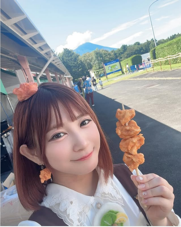 有野いくが唐揚げ棒を持って笑っている