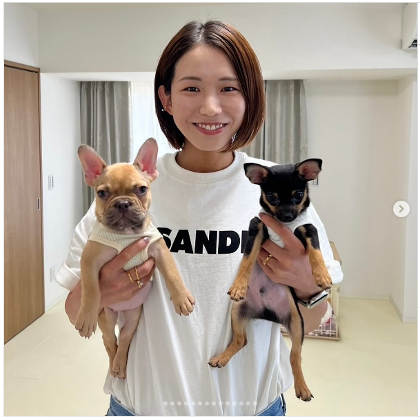 古賀紗理那が犬2匹を抱き上げている